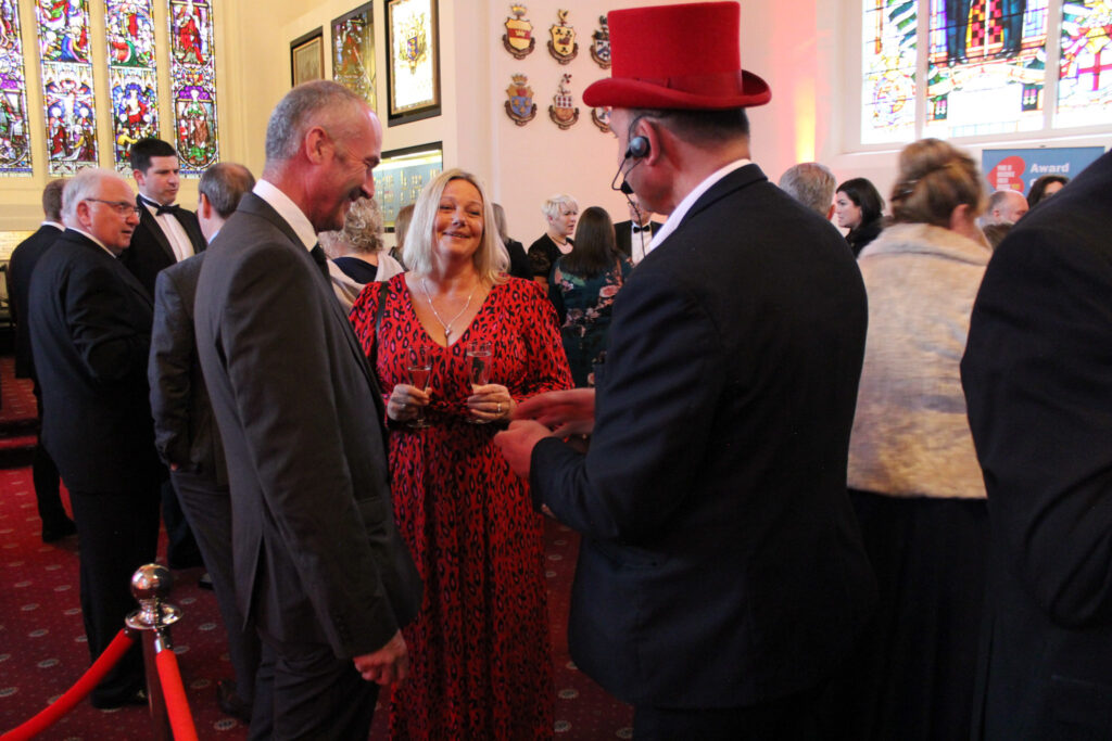 Picture of reception of the Award night with one of the entertainment, a magician performing for guests